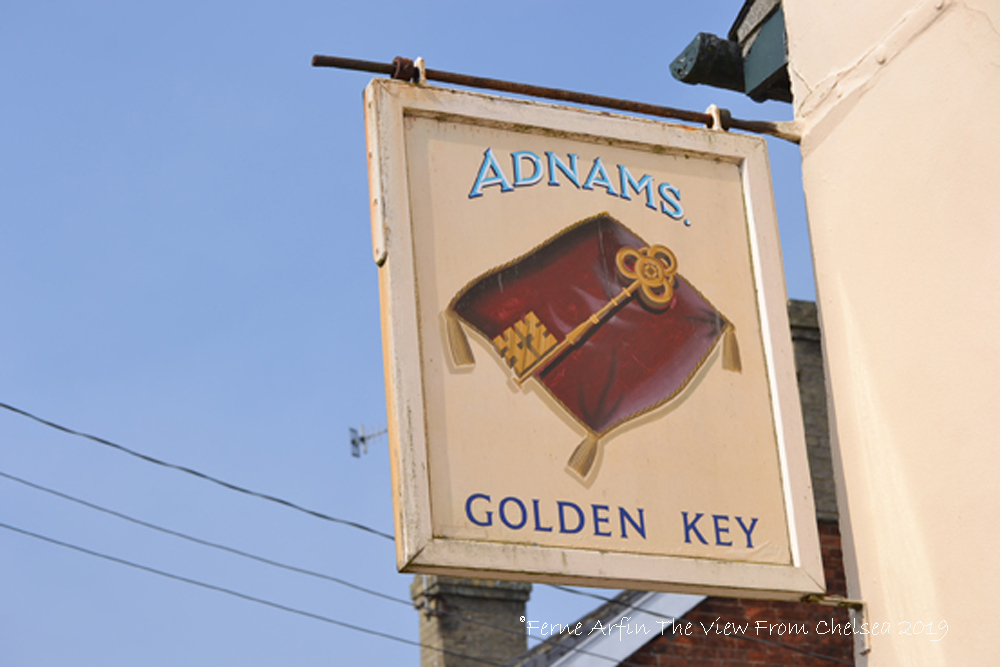 Pub sign for the Golden Key in Suffolk, Old fashioned key on velvet cushion.