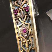 The Fan Museum Greenwich. Close up of the jewelled end of a rare, 18th century fan with rubies, diamonds and gold.