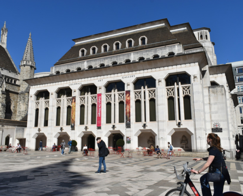 guildhall art gallery, a modern gothic style building in The City of London. Blue skies and wide plaza.