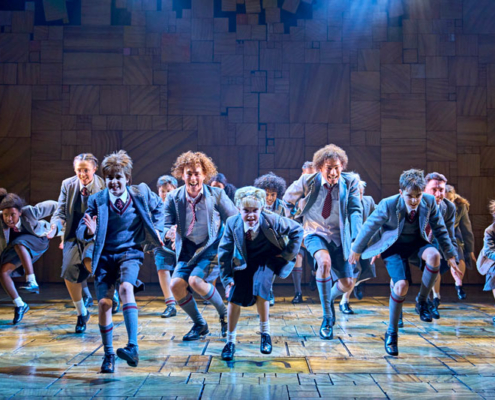 Children dancing in School Uniforms in Matilda The Musical.